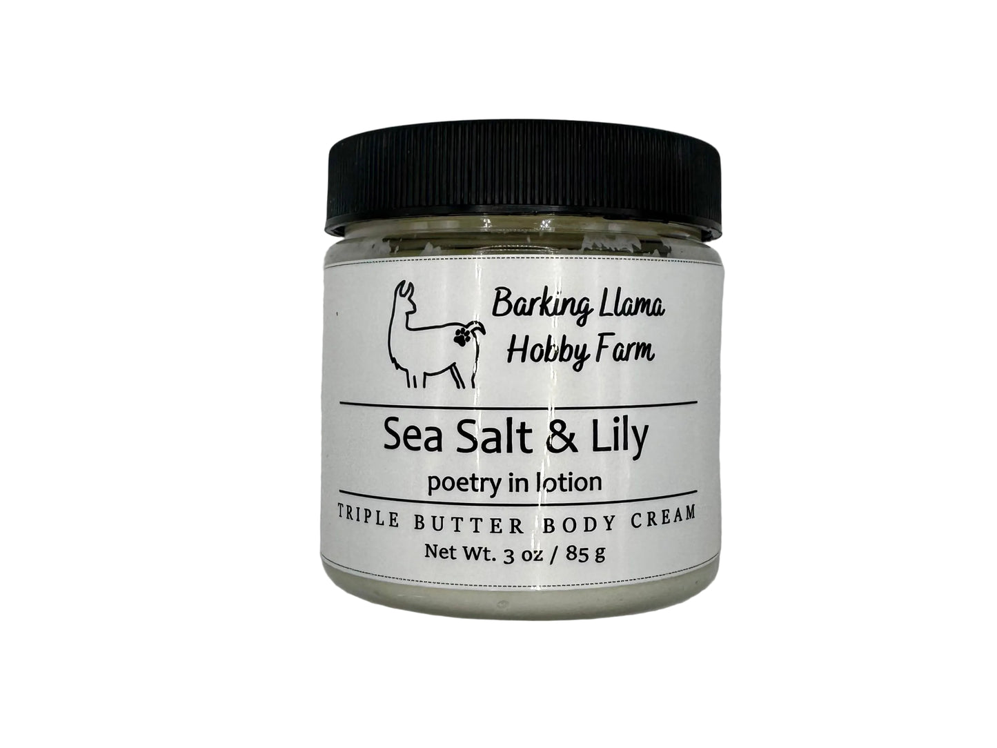 Clear jar with a black lid with white body cream inside. The label has a picture of a llama with the title of the lotion on the front.