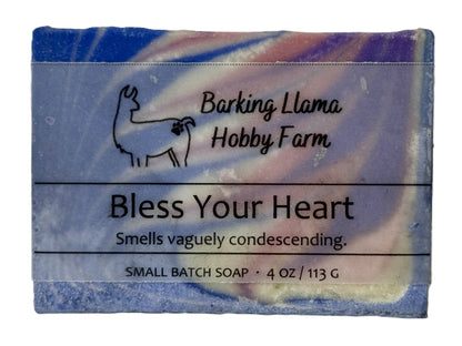 Soap bar with 'Barking Llama Hobby Farm' branding and humorous description on a white background. The soap is blue, white, pink, and purple in a swirl pattern.