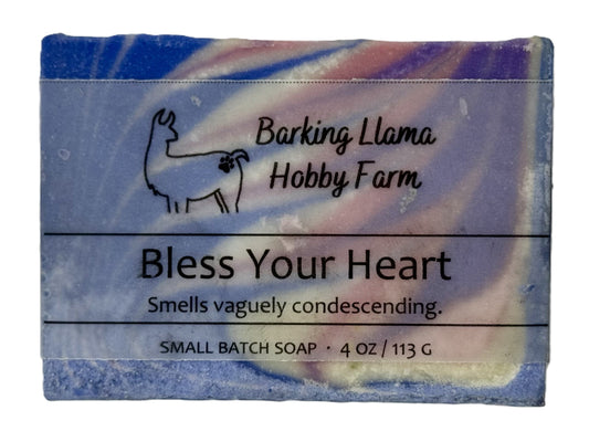 Soap bar with 'Barking Llama Hobby Farm' branding and humorous description on a white background. The soap is blue, white, pink, and purple in a swirl pattern.