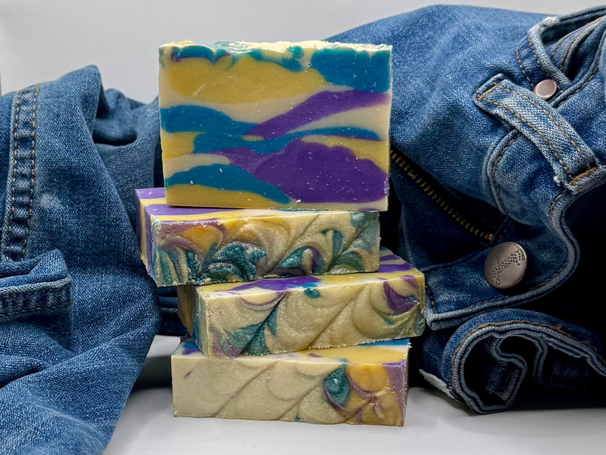 Stack of colorful soap bars with denim fabric in the background