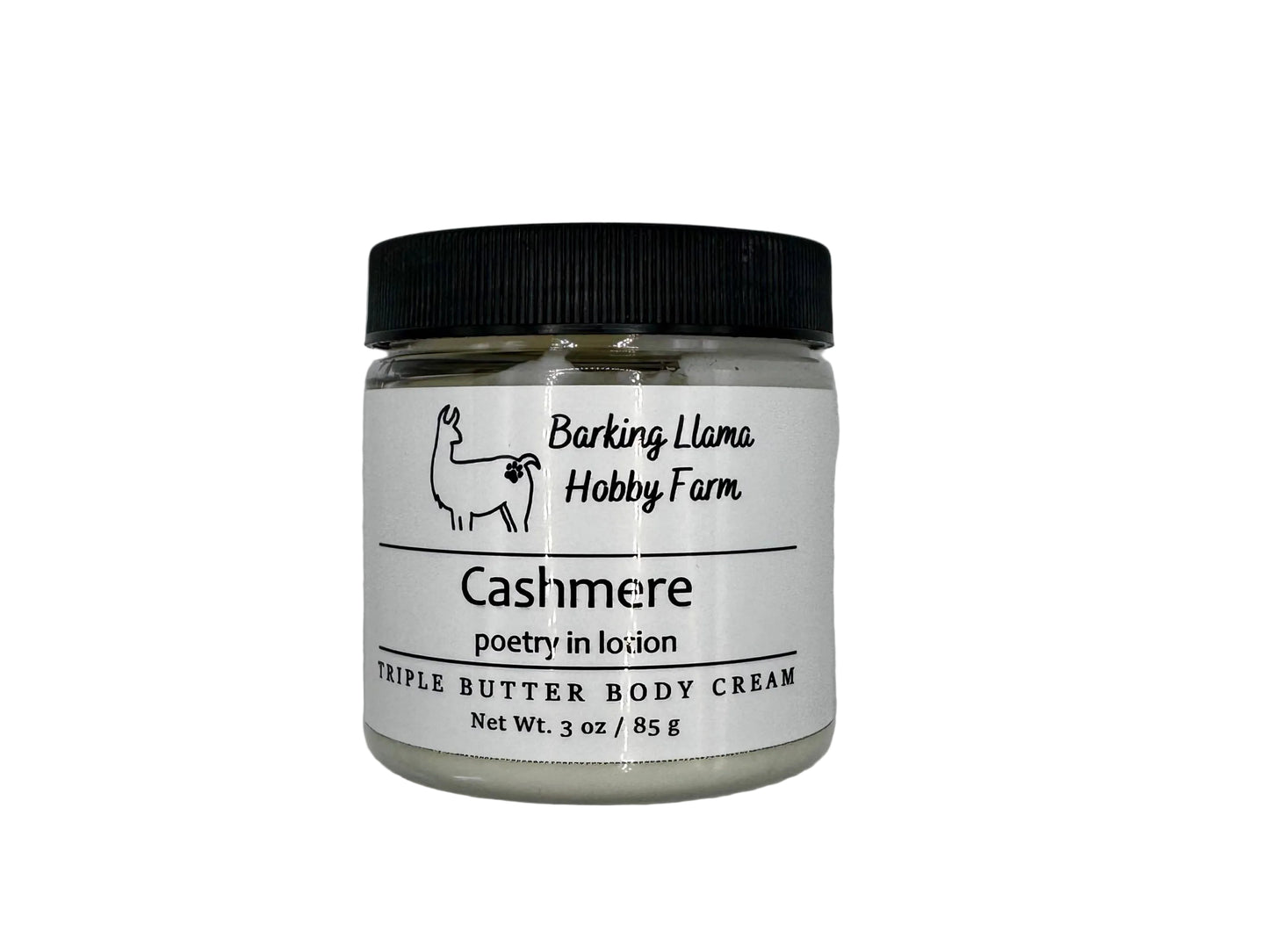 Clear jar with a black lid with white body cream inside. The label has a picture of a llama with the title of the lotion on the front.