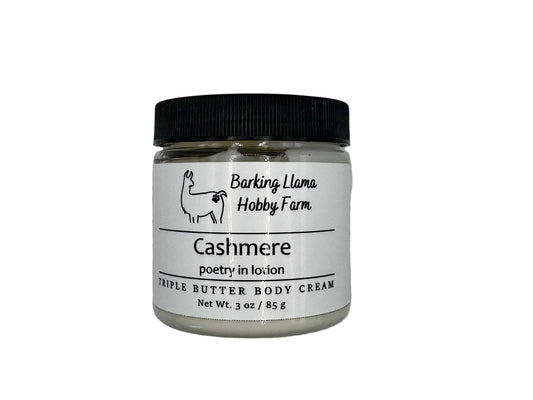 Clear jar with a black lid with white body cream inside. The label has a picture of a llama with the title of the lotion on the front.