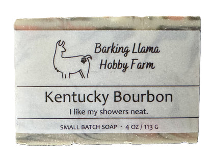 Bar of soap scented in Kentucky Bourbon fragrance. The soap is gray, white, red, and black. It is labeled with the Barking Llama Hobbby Farm logo.